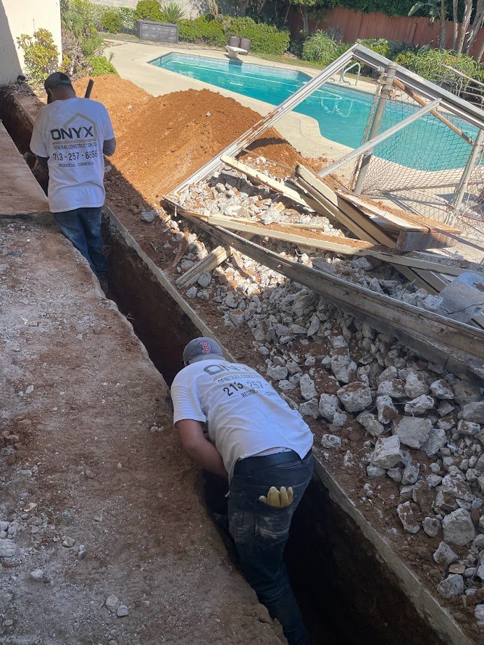 Deep exterior trenching near a poolside addition area in Los Angeles.