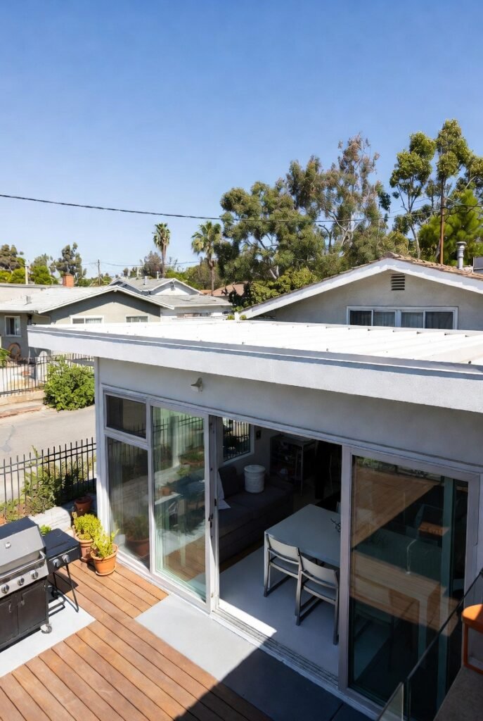 Rear yard home addition in Los Angeles with sliding glass doors and a hardwood deck designed by Onyx General Construction.