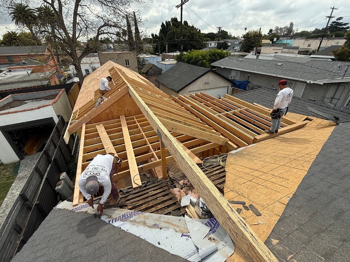 Structural roof framing underway on a Los Angeles home addition, showing engineered beams and carefully aligned rafters during construction..